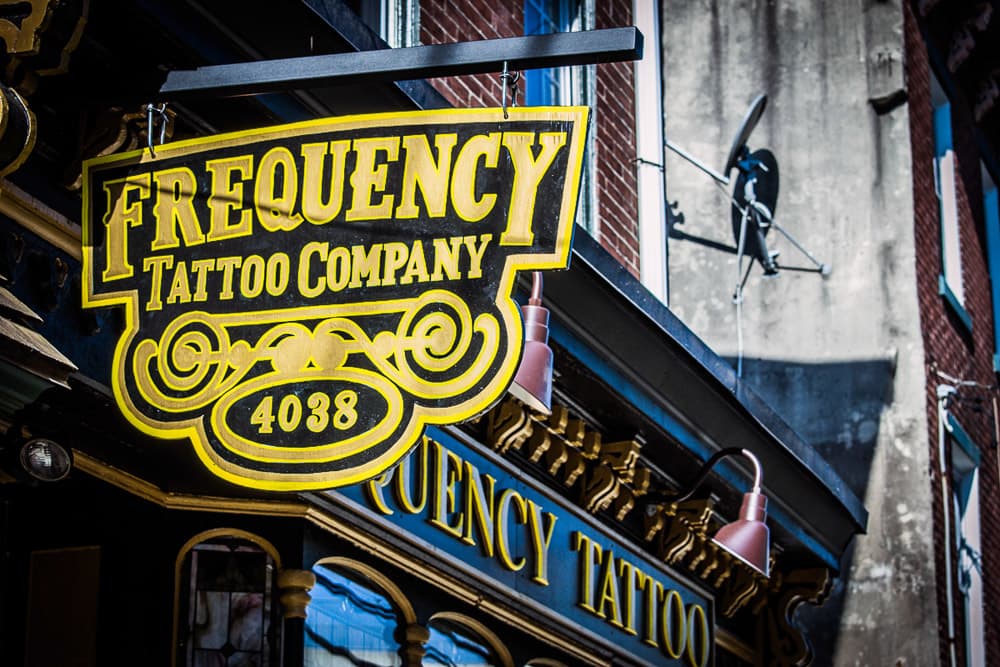 Frequency Tattoo Company gold signage