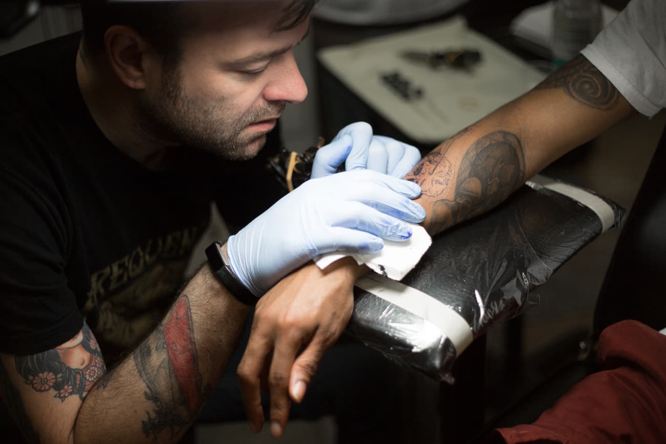 John Howie tattooing a client
